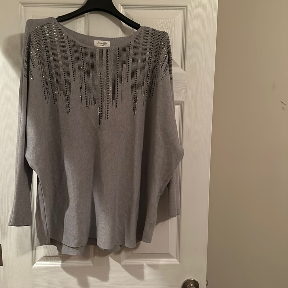 A gray pre-fall sweater embellished with silver and black rhinestones.